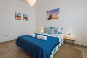 1 dormitorio con 1 cama con 2 toallas en By the C house en Vila Nova de Milfontes