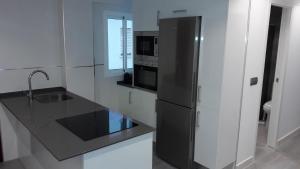a kitchen with a black refrigerator and a sink at GUESTING VELAZQUEZ in Cádiz