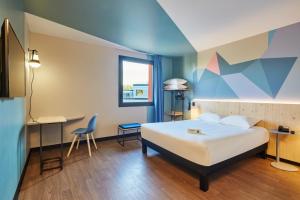 Courcouronnesにあるibis Styles Evry Lissesのベッドとデスクが備わるホテルルームです。