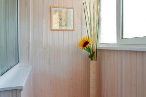 un jarrón con un girasol en una esquina de una habitación en Apartment on 40 let Oktyabrya 8 en Voronezh
