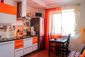 cocina con mesa y nevera en Apartment on 40 let Oktyabrya 8 en Voronezh