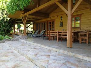 an outdoor patio with wooden tables and chairs at Szypry - wakacyjny dom nad jeziorem in Barczewo