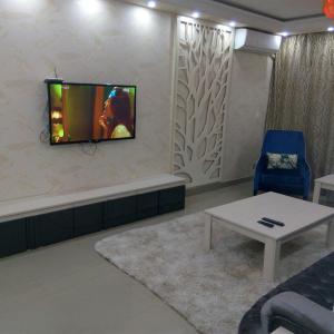 een woonkamer met een tv aan de muur bij City Stars Two Bedroom in Caïro