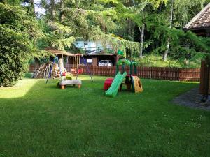 a yard with a playground with a slide at Szypry - wakacyjny dom nad jeziorem in Barczewo