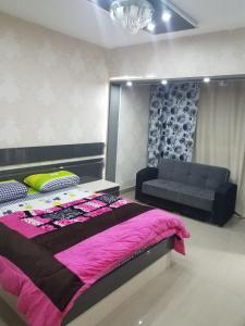 een slaapkamer met een groot bed en een bank bij City Stars Two Bedroom in Caïro