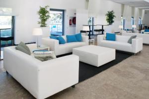a living room with white couches and blue pillows at INATEL Caparica in Costa da Caparica