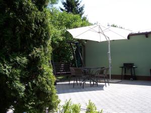 uma mesa e cadeiras com um guarda-sol num pátio em Ambelia em Stegna