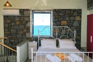 a bedroom with a bed with a large window at Fanaraki villas in Moudhros