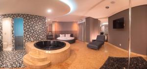 uma grande casa de banho com uma banheira e uma cama em Motel Decameron (Adults Only) em Salvador
