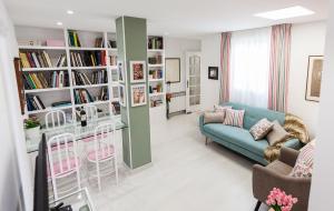 a living room with a couch and a table and bookshelves at Ático en el centro junto al Espolón in Logroño