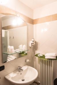 a bathroom with a sink and a mirror and towels at Agriturismo Corte Del Brenta in Oriago Di Mira