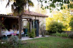 una casa de piedra con una mesa en un jardín en Le Petit Cochon, en Valence-sur-Baïse