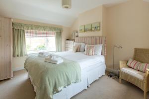 a bedroom with a large white bed and a window at 18 Pilgrim’s Way in Thorpeness