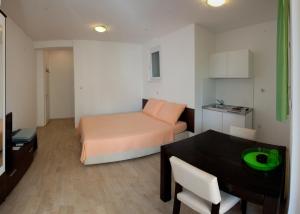 Kleines Zimmer mit einem Bett und einem Esstisch in der Unterkunft Apartments Klara in Split