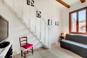sala de estar con escalera y silla en San Marcuola apartment, en Venecia
