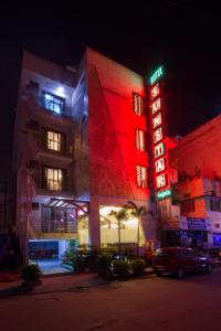 Hotel Sunstar Heights في نيودلهي: مبنى عليه علامة نيون في الليل