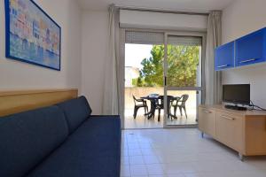 a living room with a couch and a table with chairs at Parco Hemingway in Lignano Sabbiadoro