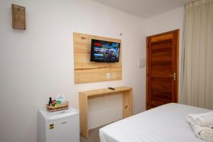 Habitación con 2 camas y TV en la pared. en Pousada Barra del Mundo en Barra Grande