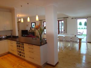 a kitchen and living room with a table and chairs at The Gables in Hout Bay