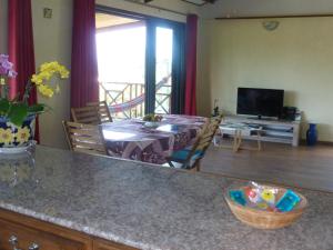 a kitchen and living room with a table and a television at Chez Solange et Michel in Sainte-Rose