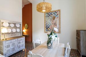 a dining room with a table and a vase of flowers at Teatro Suites Málaga in Málaga +80 photos