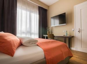 a bedroom with a bed with a television and a desk at anders Kontorhaus Hotel in Lüneburg