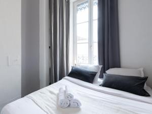 a bedroom with two towels on a bed with a window at Le Nid Lyonnais - Le Vienne in Lyon