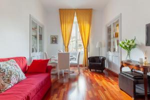 a living room with a red couch and a table at Leonardo Suite Navona in Rome