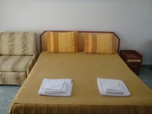 a bed with two towels on it with a couch at Svetlana Hotel in Byala +38 photos
