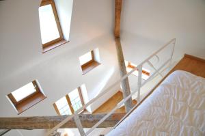 1 dormitorio con 1 cama y una escalera con ventanas en La Tour de Serinchamps, en Serinchamps