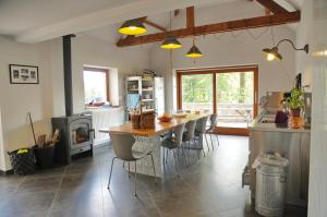 een keuken met een tafel en stoelen in een kamer bij La Tour de Serinchamps in Serinchamps