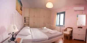 a bedroom with a white bed and a chair at Petra Traditional House in Episkopión