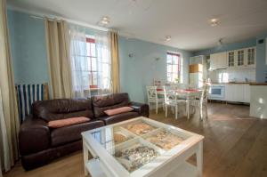 ソポトにあるGrand Apartments - Nautica Deluxe Apartmentのリビングルーム(革張りのソファ、テーブル付)
