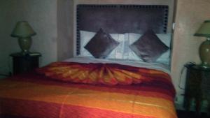 un letto con un grande testiera con cuscini sopra di Dar Narjis a Marrakech