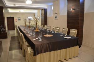 a long table with chairs and wine glasses on it at Hotel Racibor in Racibórz
