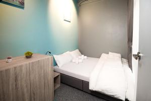 Kleines Zimmer mit einem Bett und einem Holzschrank. in der Unterkunft Vibrant Hostel in Kota Kinabalu