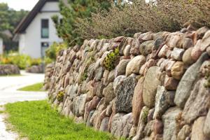 a stone retaining wall with plants on it at Kapitänsweg 07 in Ostseebad Karlshagen