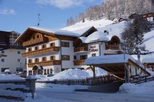 a large building with snow on the roof at Garnì Tofana in Corvara in Badia