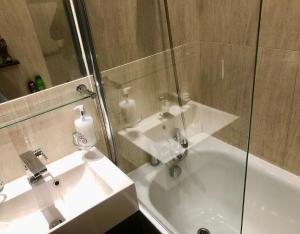 bagno con lavandino e doccia in vetro di Luxury apartment in Central London, Mida Vale a Londra