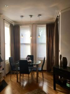 una sala da pranzo con tavolo in vetro e sedie di Luxury apartment in Central London, Mida Vale a Londra