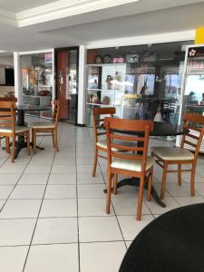 a restaurant with wooden chairs and tables in a store at APART HOTEL MARINAS TAMANDARÉ - Flat 104 in Tamandaré