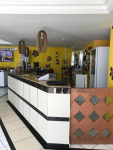 a kitchen with yellow walls and a counter top at APART HOTEL MARINAS TAMANDARÉ - Flat 104 in Tamandaré +13 photos