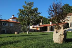 a large rock in the grass in front of a house at Casa da Capela in Paredes de Coura