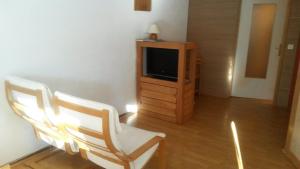a living room with two chairs and a television at Ski Soleil 108 in Manigod +2 photos