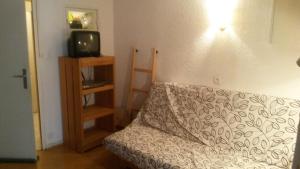 a living room with a couch and a tv at Ski Soleil 108 in Manigod