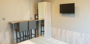 a bar with stools and a television on a wall at Appartement Studio Tournai in Tournai