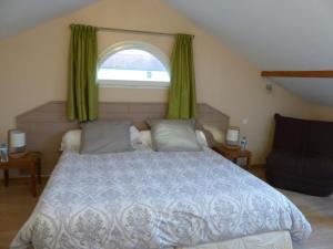 a bedroom with a large bed and a window at Les Enselmes in Montagnieu