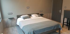 a bedroom with a bed with white sheets and pillows at Appartement Studio Tournai in Tournai
