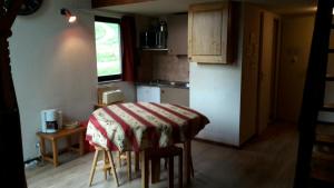 a kitchen with a table with a red and white blanket on it at LE Refuge 4005 in Manigod