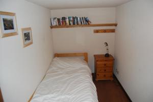 - une petite chambre avec un lit et une commode en bois dans l'établissement LE Refuge 4005, à Manigod